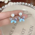Macro view of blue enamel butterfly earrings with colorful zircon and pearls on silver studs - Blue (HE32860)