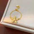 Close-up of gold adjustable chain ring featuring a pavé-set flower charm on a display box. - Pave Zirconia Flower Style (HR3513-2) / White
