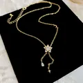 Detailed close-up of gold star necklace with sparkling zircon teardrop tassel pendant. - Necklace (HN12703) / Gold