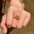 Elegant dopamine style golden flower ring with pave set stones shown on a hand - Pave Zirconia Flower Style (HR3513-2) / Yellow