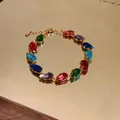 Macro detail of a gold-plated bracelet featuring colorful teardrop-shaped zircon stones - Bracelet - Gold / Colorful