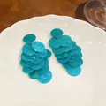 Dettaglio orecchini a strati in acrilico marmorizzato verde acqua su piatto - Ago d'argento / Blu
