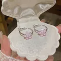 Detail view of pink resin flower hoop earrings inside a white shell-shaped jewelry box - Silver-Pink