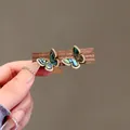 Close-up detail of retro butterfly earrings with shimmering sea shell and micro-zircon. - Sea Shell Butterfly Style (HE32373-1) / Gold And Green