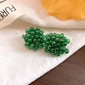 Macro detail of exquisite green beaded flower stud earrings with silver needles - Green