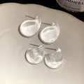 Macro detail of transparent acrylic drop earrings with steel pins on a minimalist ceramic dish - Double Bracelet Set / Clear