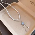 Close-up of double-layered necklace with pearls, blue cloud pendant, and zircon tassels - White Cloud Style