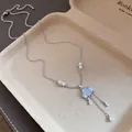 Close-up of silver necklace featuring blue cloud charm and pearl tassel drops - Blue Cloud Tassel Style