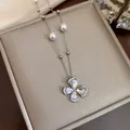 Macro detail shot of an elegant zircon flower and pearl necklace in gold plating - Silver
