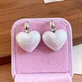 Dettaglio ravvicinato di orecchini vintage con perle a cuore in una scatola di velluto - Orecchini a Lobo con Perle a Cuore / Argento-Bianco Perla