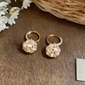 Gros plan sur les boucles d'oreilles boule de fleurs dorées 18k et zircons brillants - Style Créole Boule de Fleurs (1#) / Or