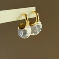 Detalle macro de elegantes pendientes dorados en forma de C con colgantes de resina - Pendientes de Patchwork en C (HE34154-1) / Oro-Blanco