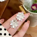 Detail view showing intricate texture of silver flower stud earrings with micro-pave zirconia - Large Flower Style (HE32460) / Silver
