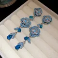 Close-up of vintage flower tassel earrings featuring vibrant blue stones and silver plating. - Silver Blue