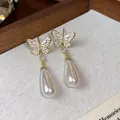 Detail von vergoldeten Schmetterlingsohrringen mit eleganten weißen Tropfenperlen - 2# Schmetterlings-Anhängerstil (HE31295)