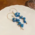Detailed view of elegant blue floral ear cuffs with pearl accents on a cream plate. - Ear Hanging Style (HE32098) / Gold-Blue