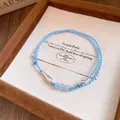 Detalle exquisito de una pulsera de cordón trenzado azul con pez plateado y cuentas. - Estilo Cuerda Trenzada / Azul