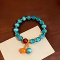 Elegante bracciale retrò di perle occhio di gatto con nappa etnica in blu vibrante. - Blu