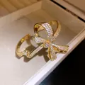 Detailed view of gold bow bracelet pavé-set with sparkling cubic zirconia stones - Gold