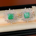 Primo piano dei dettagli degli orecchini a perno in zircone verde smeraldo in un cofanetto - Stile Fuochi d'Artificio Quadrati (HE34013) / Argento-Verde