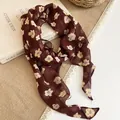 Detailed shot of a burgundy chiffon neck scarf featuring a cream floral print and soft texture - Coffee Floral Print