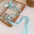 Detail of elegant light blue satin ribbon bow hair accessory for balletcore fashion styles - Blue