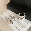 Detailed view of silver multi-layer earrings with black polka dots in retro style. - Silver