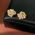 Dettaglio macro di orecchini a fiore placcati oro 18K con splendenti pietre di zircone - Placcato Oro 18K / Un Paio / Oro