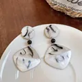 Gros plan de boucles d'oreilles en résine marbrée style encre de Chine - Style Pendant Géométrique Irrégulier / Résine Beige et Noir Estompé