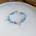 Gros plan d'un bracelet de fleurs en perles bleues fait main avec des perles pour l'été. - Bracelet / Bleu-Blanc