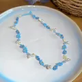 Vue macro détaillée d'un doux collier de fleurs en perles bleues avec accents de perles - Collier / Bleu-Blanc