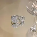 Detailed macro shot of an elegant eight-pointed star and zircon pavé open ring design. - Open Adjustable Style / Silver