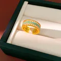 Dettaglio di un anello dorato con tre file di zirconi bianchi e perline color turchese - Aperto (HR3529) / Oro-Verde