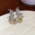 Macro view of silver butterfly stud earrings featuring glass drops with colorful dots - Butterfly Design