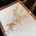Detailed macro shot of a vintage gold multi-layered necklace featuring pearls and keys - Gold
