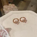 Detailed view of rose gold flower hoop earrings with sparkling cubic zirconia stones - Rose Gold