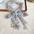 Elegant pastoral style blue floral chiffon necktie scarf tied in a bow on a tray - Grey Floral