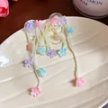 Detailed view of long tassel earrings with colorful glass flowers and white pearls - Colorful
