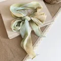 Pastoral style gradient green chiffon neckerchief tied in a bow on a book - Blue And Green Floral