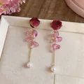 Detail view of elegant red rose eternal flower earrings with pink petals and pearl - Silver Earring Post Style / Rose Red