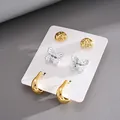 Dettaglio del set di 6 orecchini con bottoni dorati, farfalle argentate e orecchini a cerchio - Set da 6 (3 Paia) / Combinazione Oro e Argento