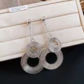 Detail shot of oversized silver metal earrings with concentric textured circles - Silver Earring Post Style / Silver