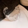 Close-up detail of the silver metallic cuff bracelet featuring an elegant pleated leaf design - Silver (Size 8)