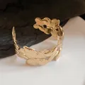 Detailed view of a gold-toned butterfly motif open cuff bracelet with textured wings - Gold (1#)