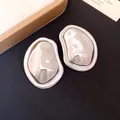 Detail view of silver pleated metallic earrings with an irregular oval shape. - Earrings (Silver Earring Post) / Silver