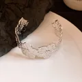 Detailed view of silver-tone metal cuff bracelet with intricate floral petal cutout design. - Silver (6#)