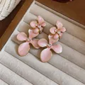Close-up of elegant pink enamel flower earrings with sparkling rhinestone centers. - Silver Earring Post - Pink