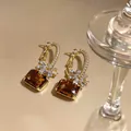 Elegante goldene Creolen mit braunen Edelsteinen und Kristallblumen-Details im Nahaufnahme - Bernstein Zirkonia Blumenstil / 925 Silberstecker / Goldbraun