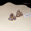 Detailed macro view of elegant lavender octagonal crystal stud earrings on cream tray. - Rectangular Style (HE32832) / Purple