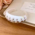 Detailed view of a white resin cuff bracelet adorned with silver round rivets - Bangle / Ivory